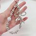 Light Luxury Style Electroplated Bow Inlaid Diamond Beads Mobile Phone Chain Student Bag Pendant_voghion.com