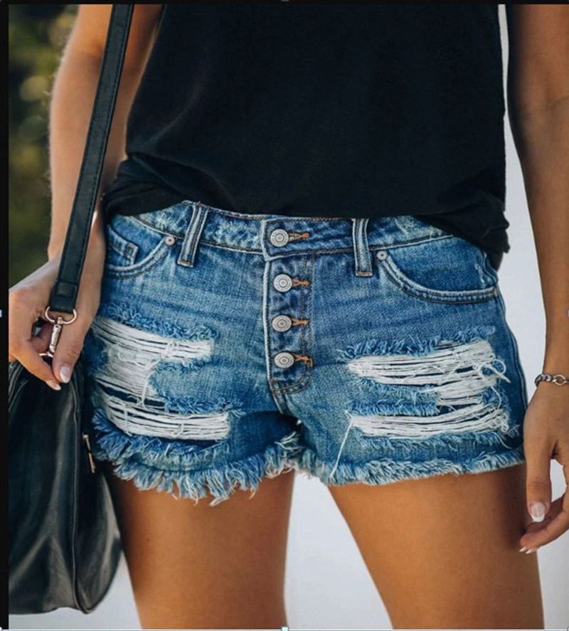 Pantaloncini in denim con frange strappate, tendenza moda estate 2025, pantaloni corti da donna_voghion.com