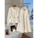 Completo invernale chic: maglione bianco lavorato a maglia e gonna a trapezio a vita alta, elegante completo coordinato in due pezzi_voghion.com