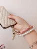 Bracciale con ciondolo mobile in pelle di perla camelia per IPhone Samsung Ciondolo con corda universale anti-smarrimento per cellulare_voghion.com