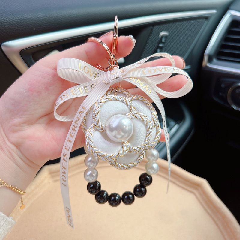 Portachiavi vintage intrecciato - Ciondolo a forma di fiore di camelia con fiocco, elegante accessorio per auto e borsa da donna_voghion.com