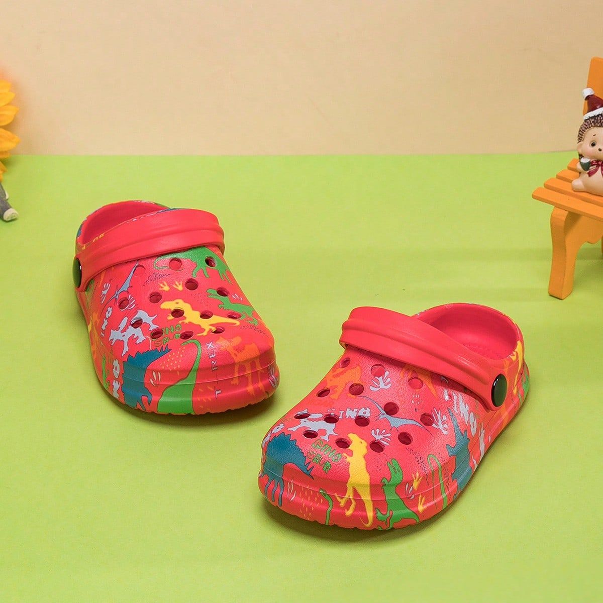 Un paio di scarpe da casa comode e alla moda per ragazzi, con stampa di dinosauri, adatte per l'estate._voghion.com