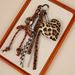Portachiavi con ciondolo per borsa in cordino intrecciato con fiocco a forma di cuore e stampa leopardata, novità autunno/inverno 2025_voghion.com