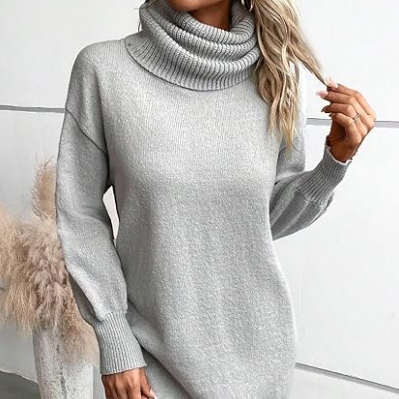 Die Rollkragenbluse für Damen ist locker geschnitten und trägt darunter einen Pullover._voghion.com