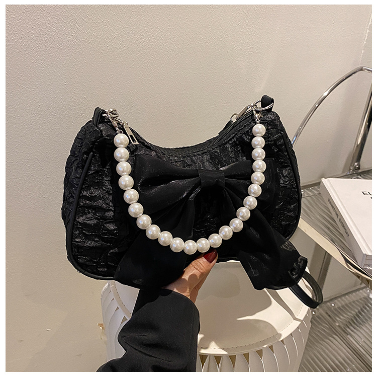 Il popolare fiocco di quest'anno per la primavera 2024 delle donne, la nuova borsa a tracolla singola sotto le ascelle con perle trendy e alla moda_voghion.com