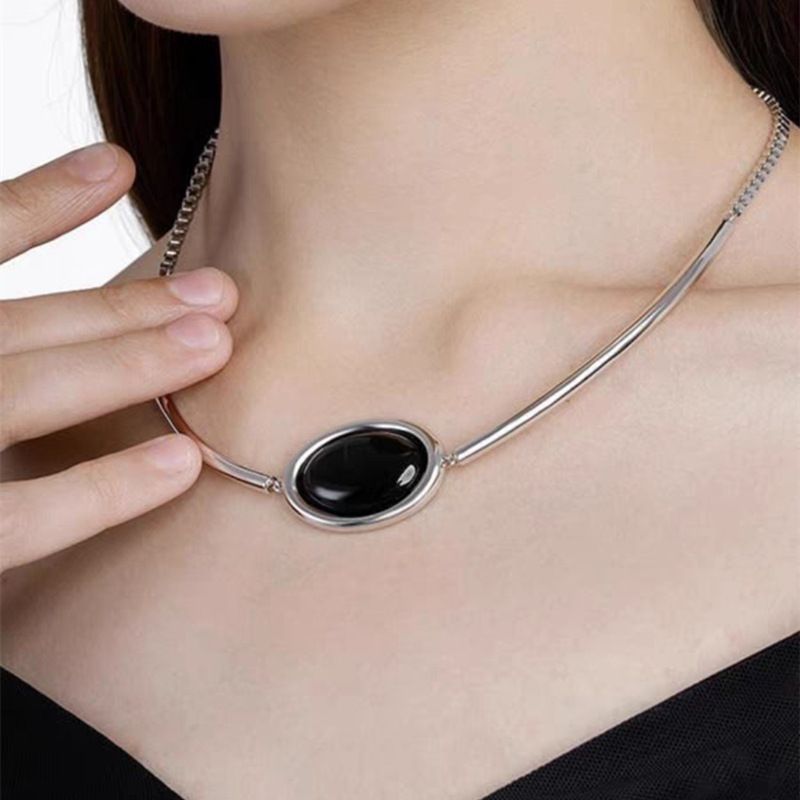 Collier élégant avec pendentif ovale en calcédoine blanche et onyx noir – Bijou minimaliste géométrique en laiton plaqué or pour femme_voghion.com