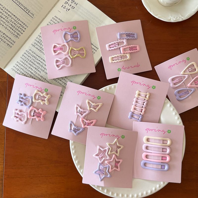 Nuovo set da 4 pezzi di accessori per capelli con frangia a forma di cuore, stella, fiocco e orsetto, in crema e rosa, 2025_voghion.com
