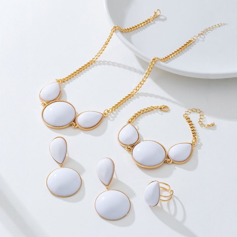 Set di gioielli da donna con collana, orecchini, bracciale e anello intarsiati con gocce d'acqua geometriche eleganti e alla moda_voghion.com