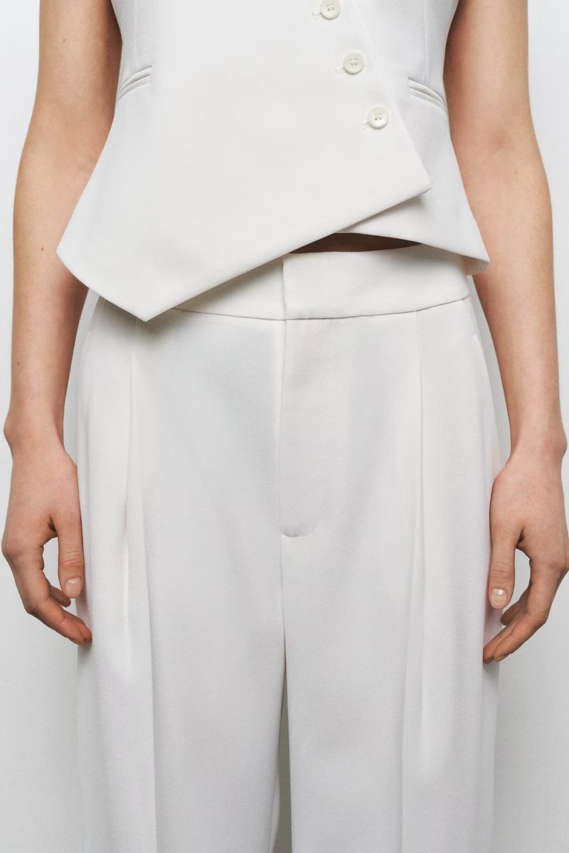 Traje de mujer de moda con chaleco asimétrico sencillo con cuello en V y pantalón ancho plisado._voghion.com
