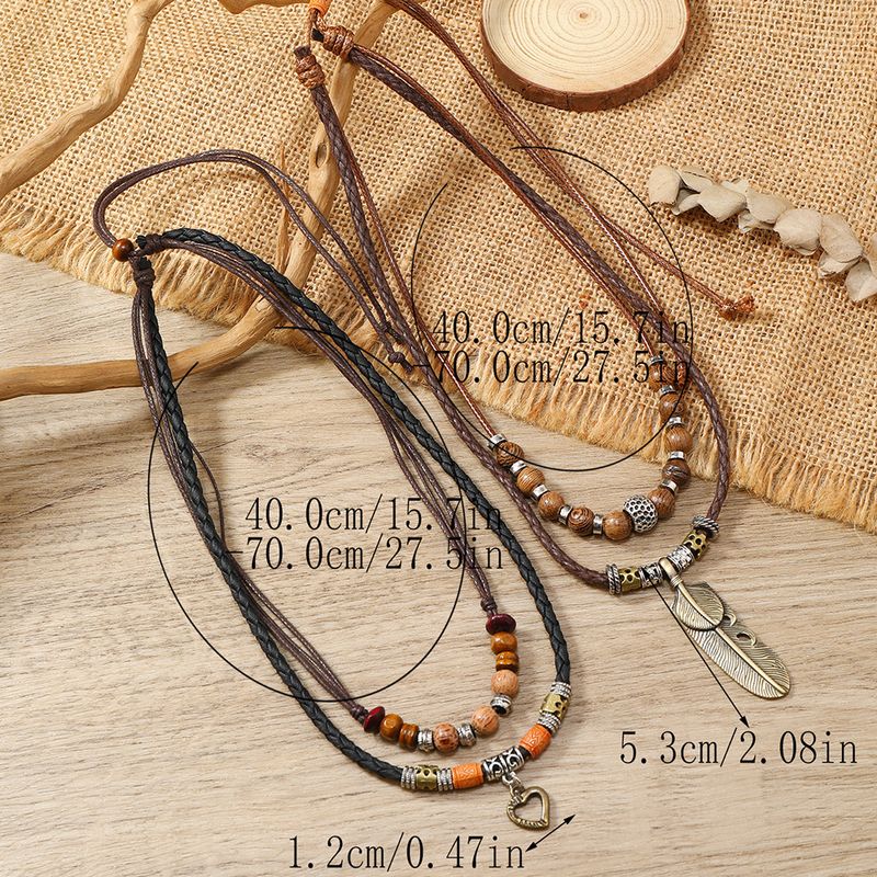 Collana in pelle multistrato semplice con ciondolo a forma di cuore con piuma e ala di pollo in legno_voghion.com