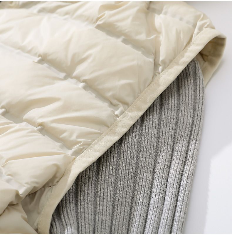 "Gilet leggero da donna slim fit in piuma d'oca, lunghezza media, con cappuccio, design laminato senza cuciture, color cachi/nero/beige"_voghion.com