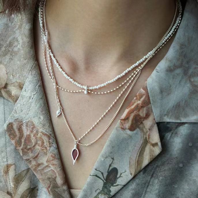 Il design della perlina rotonda in pietra di pino bianco a doppio strato in argento puro Same S di Dong Jie è semplice e realizzato a mano con un breve_voghion.com