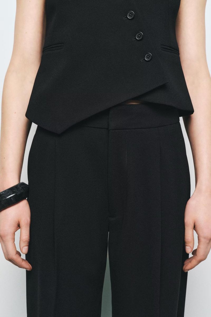 Traje de mujer de moda con chaleco asimétrico sencillo con cuello en V y pantalón ancho plisado._voghion.com