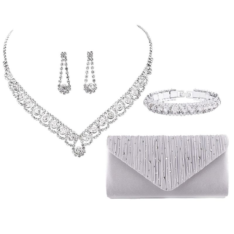Set di quattro gioielli da sposa con collana e orecchini in zircone blu, bracciale e pochette in raso con strass, borsa da sera_voghion.com