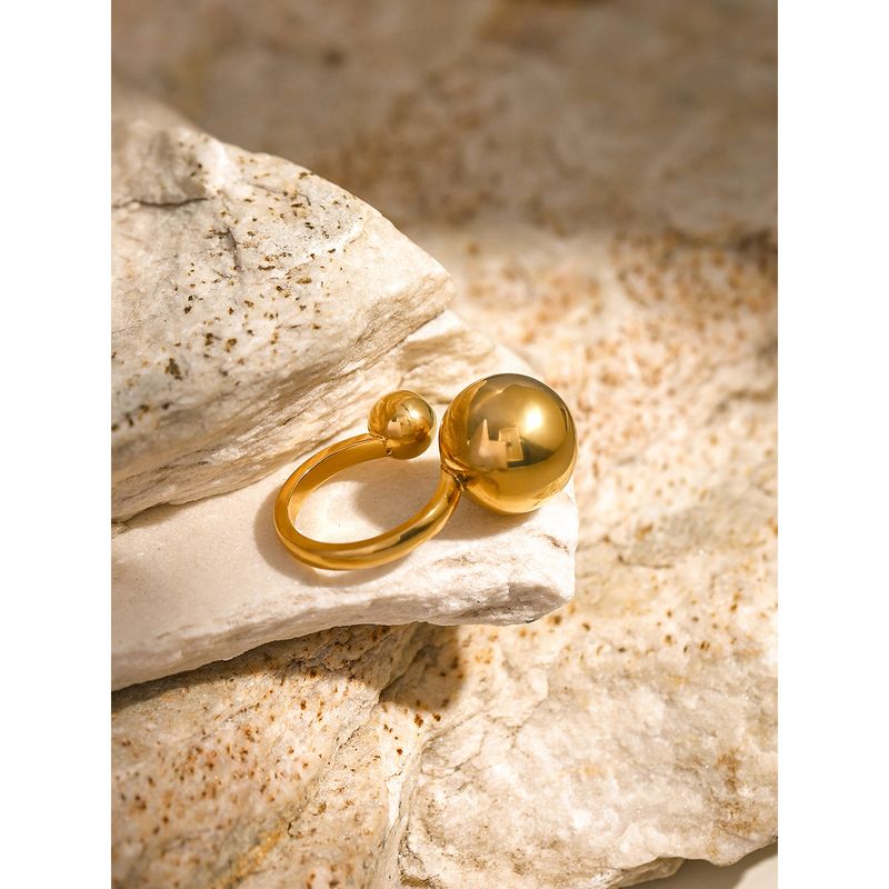Goldfarbener asymmetrischer Edelstahlring mit kleiner Kugelöffnung, trendiger roter Maschendrahtring im gleichen Stil_voghion.com