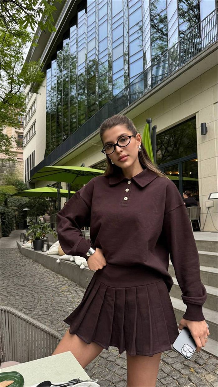 Damska bluza z kapturem zapinana na guziki, z elastyczną talią i plisowaną spódnicą – jednokolorowy, dwuczęściowy strój na co dzień, idealny na miejski styl i wygodę_voghion.com