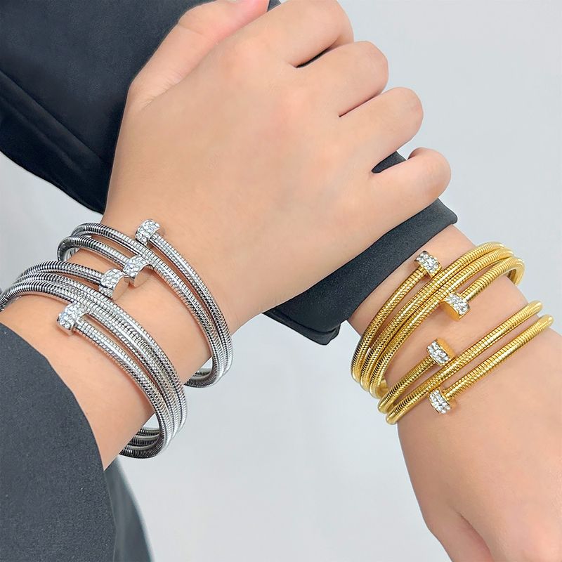 Bracciale aperto alla moda in acciaio al titanio placcato oro con zirconi sovrapposti multistrato da donna_voghion.com