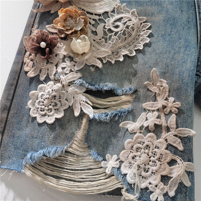 Pantaloncini in denim alla moda alla moda, con elastico in vita e strass sul retro, nuovi pantaloncini in pizzo con cuciture a fiori e fori estivi 2025_voghion.com