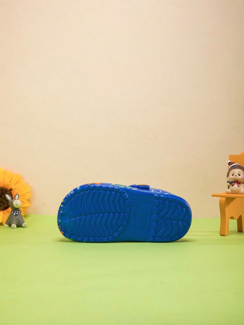 Un paio di scarpe da casa comode e alla moda per ragazzi, con stampa di dinosauri, adatte per l'estate._voghion.com