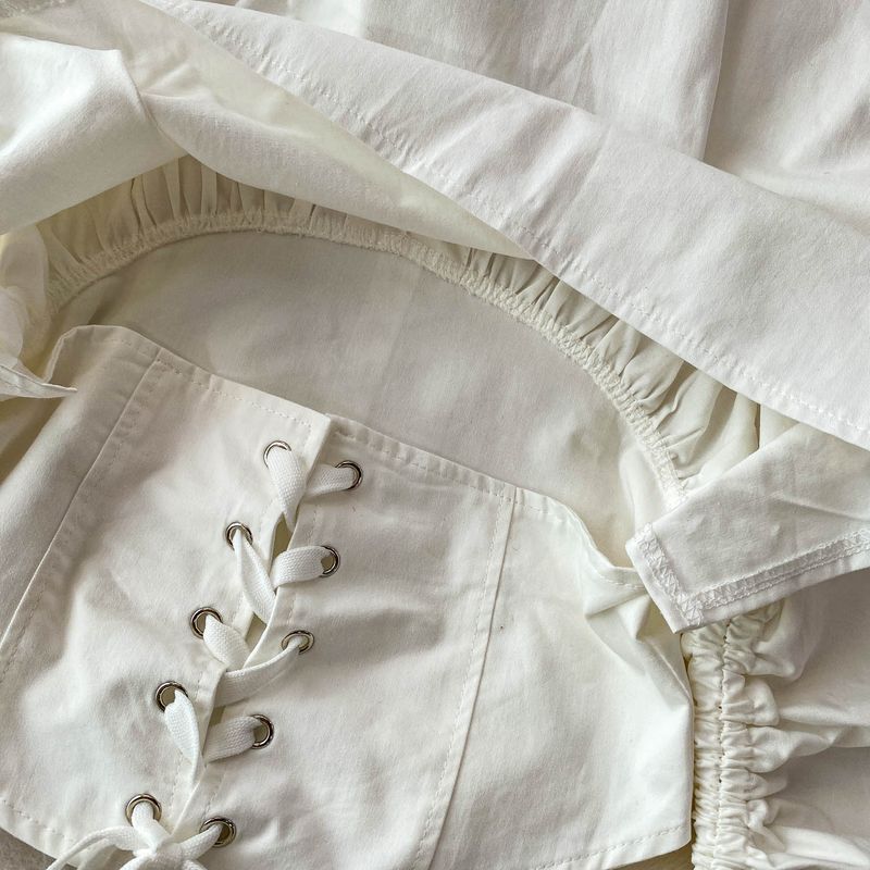 Elegante blusa con lazo en el cuello y mangas acampanadas con volantes: camisa corta de corte entallado para mujer, elegante cuello a capas y diseño que define la cintura en blanco y negro._voghion.com