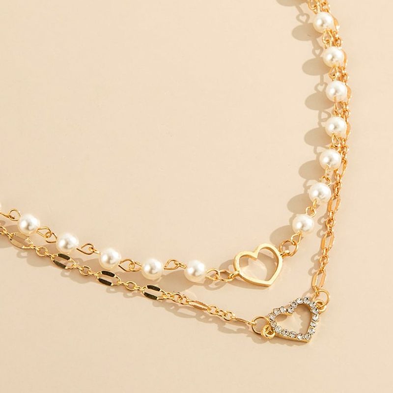 Collana girocollo con elegante perla e ciondolo a forma di cuore cavo, semplice e multistrato, per donna._voghion.com