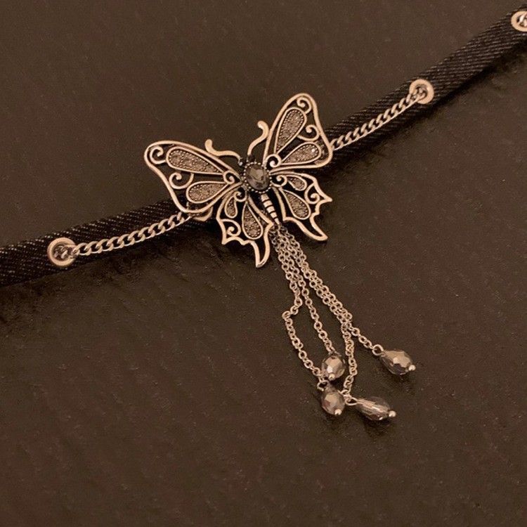 Collana girocollo corta con ciondolo a farfalla scura e frange, catena in pelle nera_voghion.com