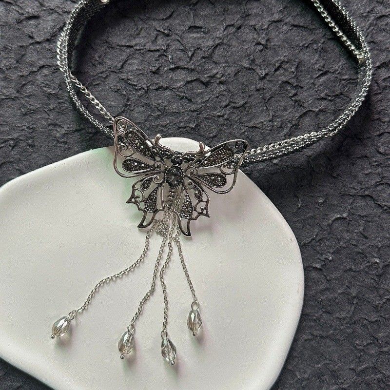 Collana girocollo corta con ciondolo a farfalla scura e frange, catena in pelle nera_voghion.com