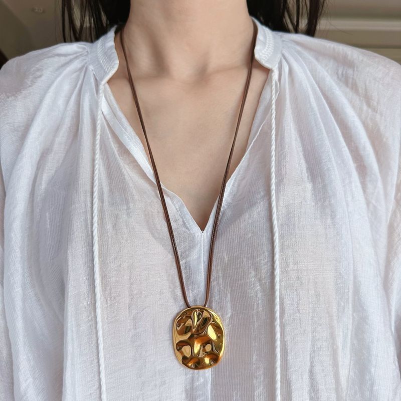 Collier pendentif géométrique en laiton martelé fait main pour femme et homme, avec corde cirée, pièce minimaliste et audacieuse pour un style unique._voghion.com