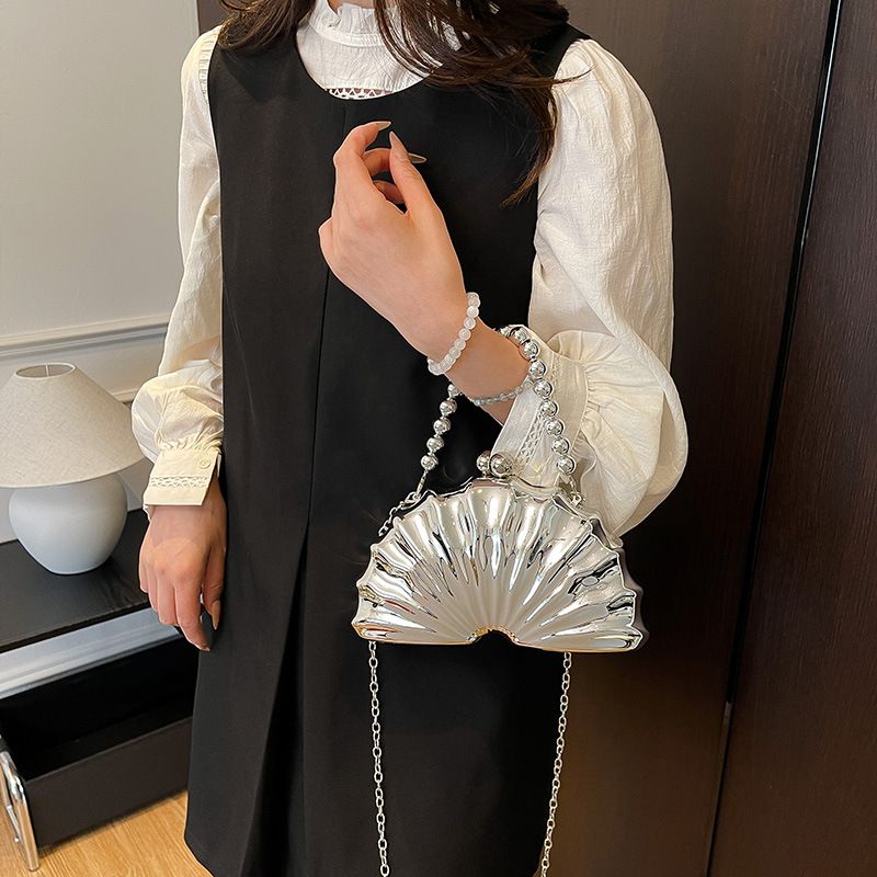 Borsa a tracolla da sera in acrilico color corallo con catena a forma di conchiglia, da donna_voghion.com