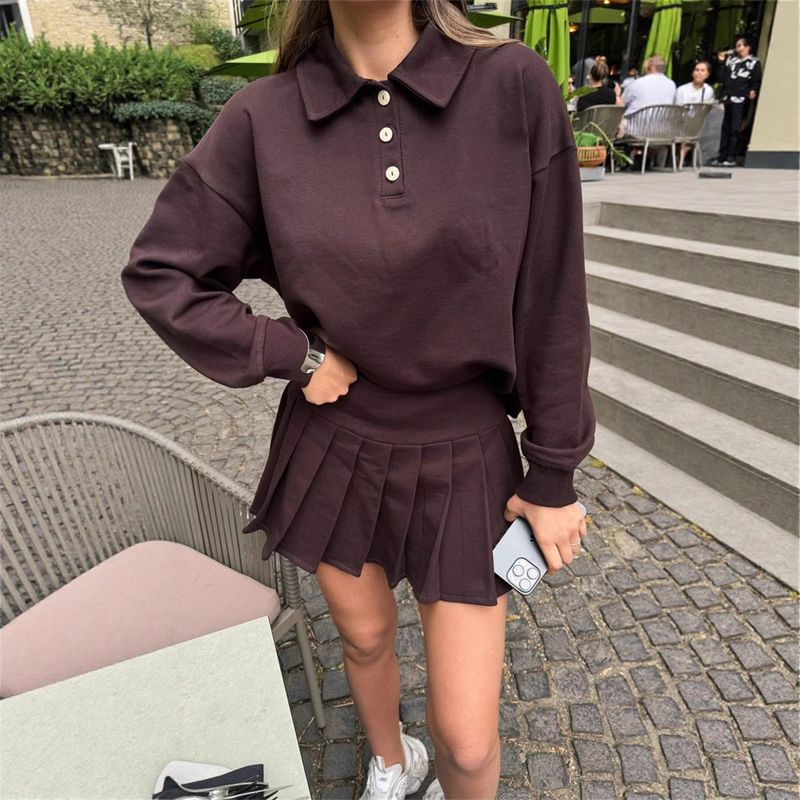 Damska bluza z kapturem zapinana na guziki, z elastyczną talią i plisowaną spódnicą – jednokolorowy, dwuczęściowy strój na co dzień, idealny na miejski styl i wygodę_voghion.com