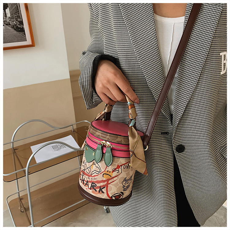 Graffiti bucket in 2024, new fashionable niche cylindrical bag, handheld one shoulder crossbody bag for women_voghion.com