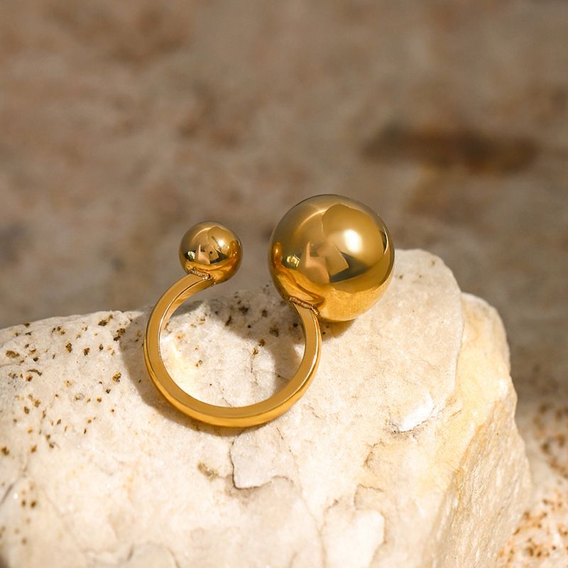 Goldfarbener asymmetrischer Edelstahlring mit kleiner Kugelöffnung, trendiger roter Maschendrahtring im gleichen Stil_voghion.com