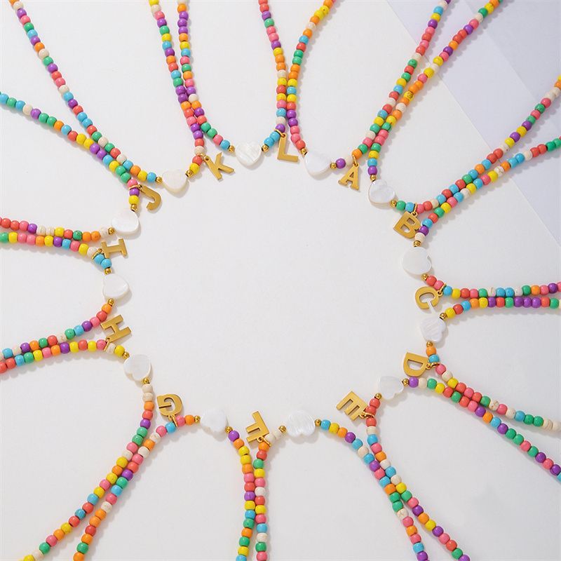 Collane girocollo con ciondolo a forma di cuore con iniziale colorata con perline e lettera dalla A alla Z per donna, in acciaio inossidabile, stile bohémien, estate, spiaggia_voghion.com