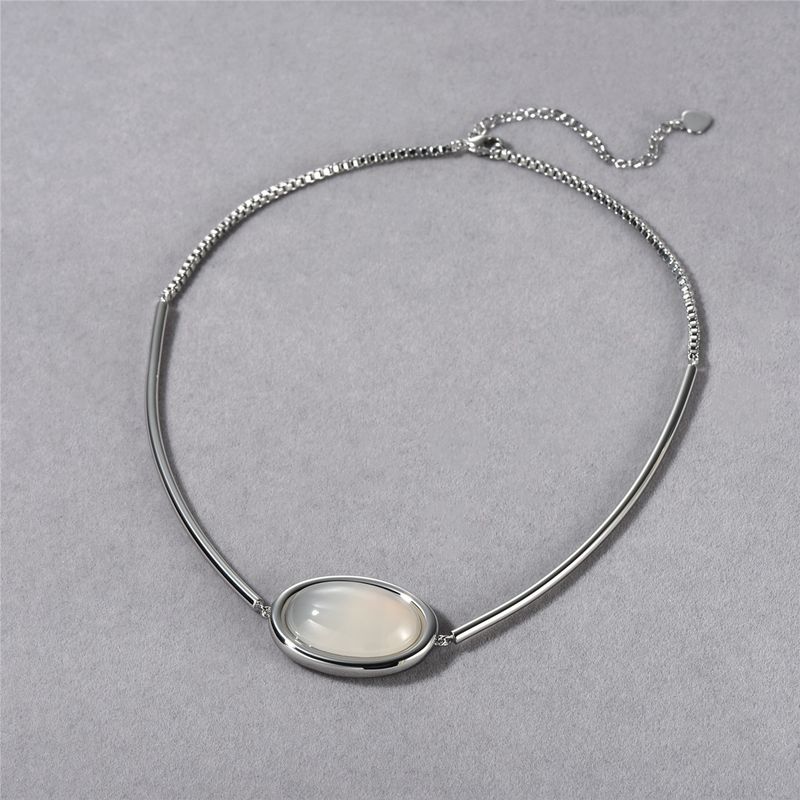 Collier élégant avec pendentif ovale en calcédoine blanche et onyx noir – Bijou minimaliste géométrique en laiton plaqué or pour femme_voghion.com