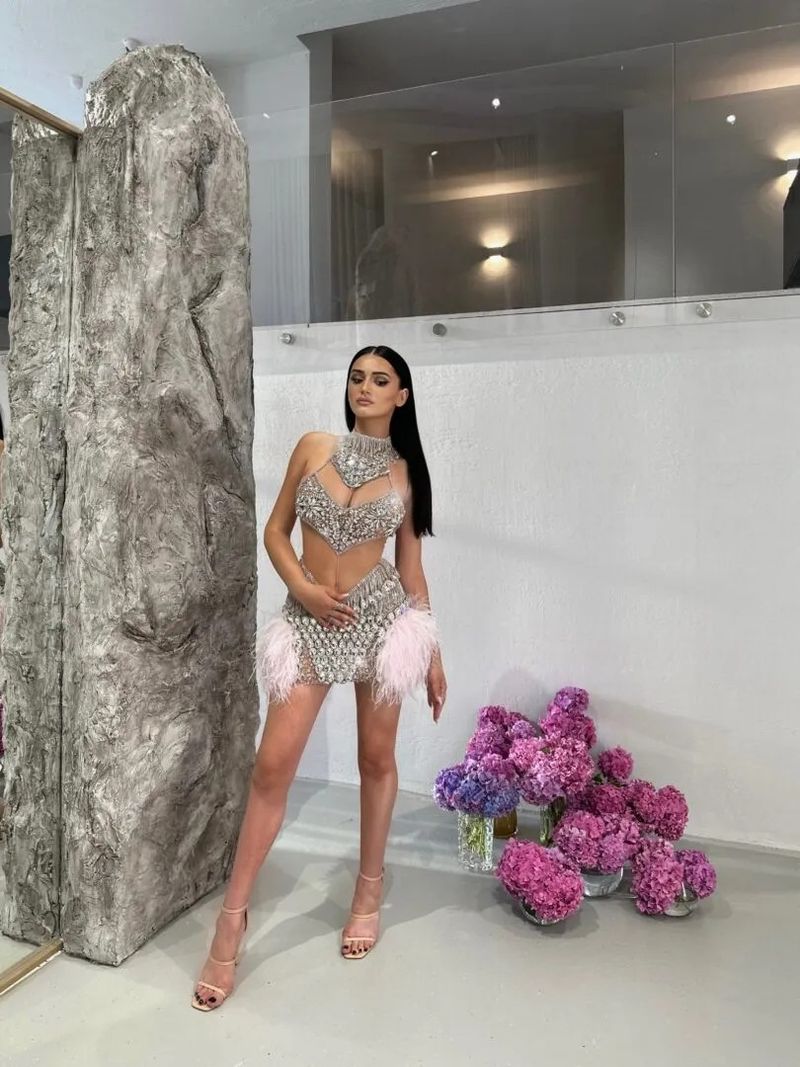 Elegante abito senza maniche in rete con paillettes e finiture in piume per feste ed eventi serali – Mini abito aderente sexy con scollo a V e decorazioni in strass_voghion.com