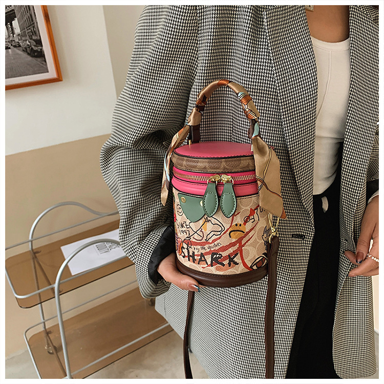 Graffiti bucket in 2024, new fashionable niche cylindrical bag, handheld one shoulder crossbody bag for women_voghion.com