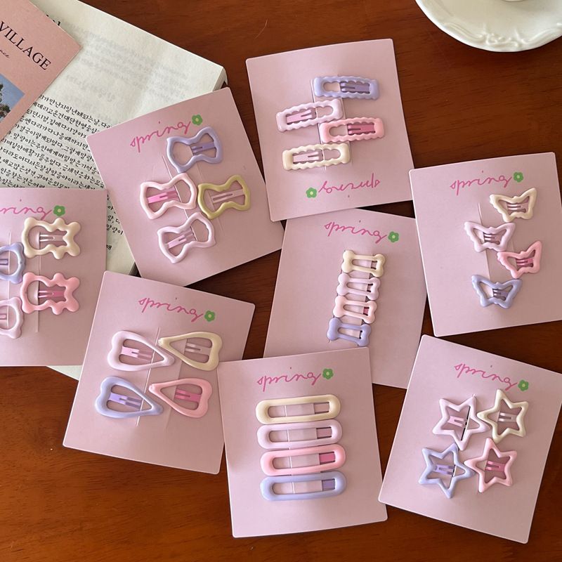Nuovo set da 4 pezzi di accessori per capelli con frangia a forma di cuore, stella, fiocco e orsetto, in crema e rosa, 2025_voghion.com