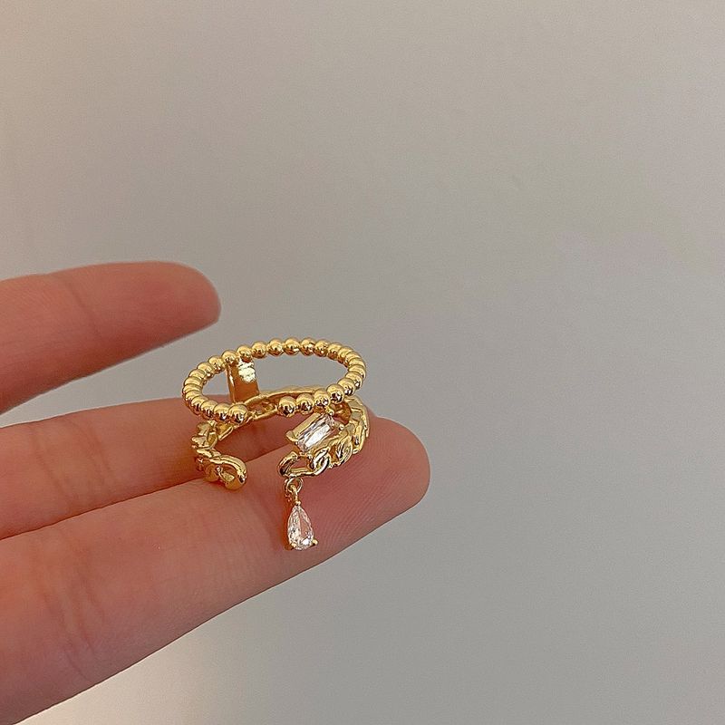 Goldfarbener, geflochtener Doppelring für Damen – Hohlzirkon-Detail, leichtes, luxuriöses Nischen-Zeigefinger-Design, verkupfert_voghion.com