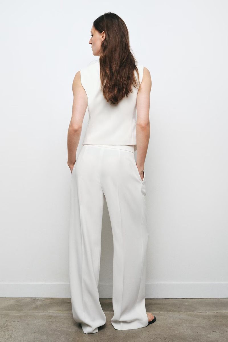 Traje de mujer de moda con chaleco asimétrico sencillo con cuello en V y pantalón ancho plisado._voghion.com