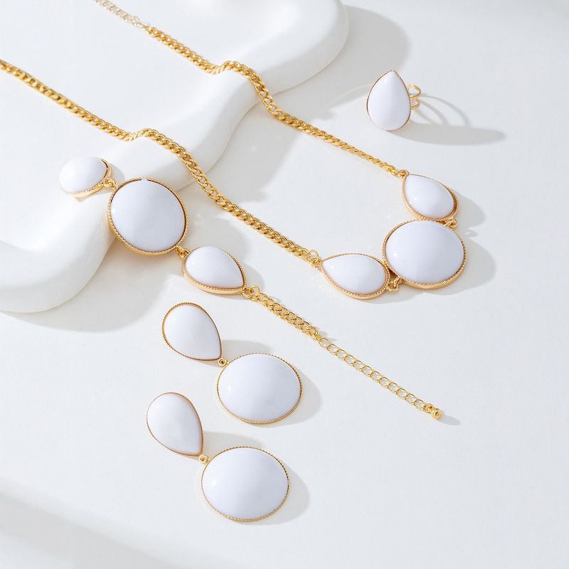 Set di gioielli da donna con collana, orecchini, bracciale e anello intarsiati con gocce d'acqua geometriche eleganti e alla moda_voghion.com