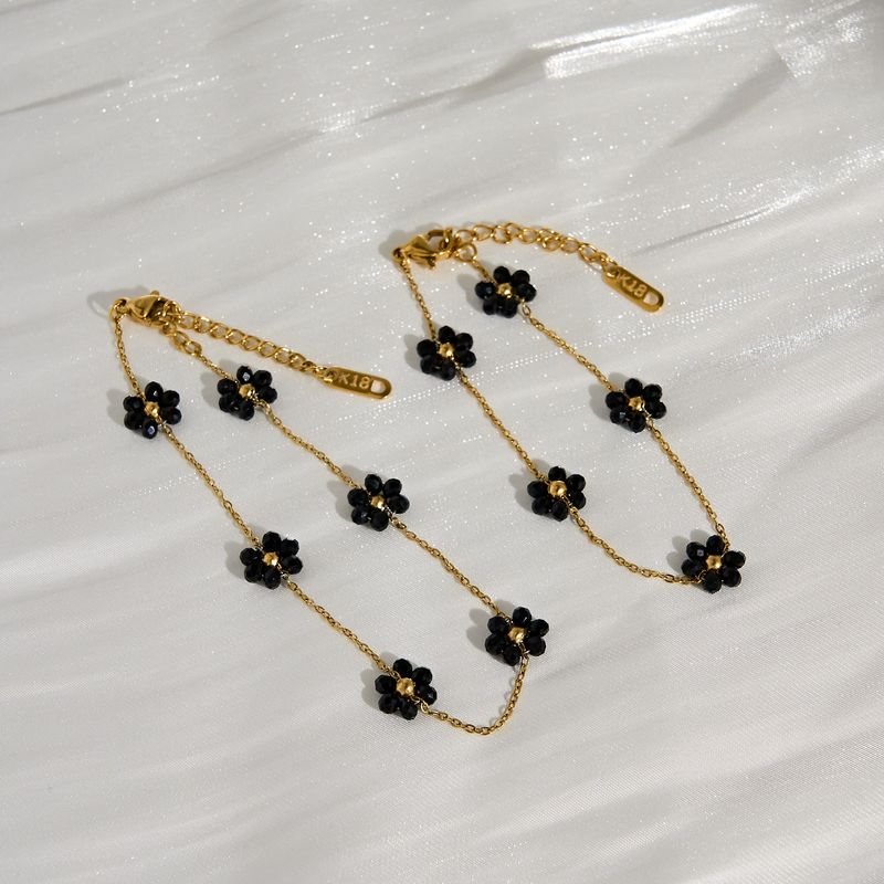 Set di collana, cavigliera e bracciale con catena in vita e fiore di margherita nera in acciaio al titanio Spot Fashion_voghion.com