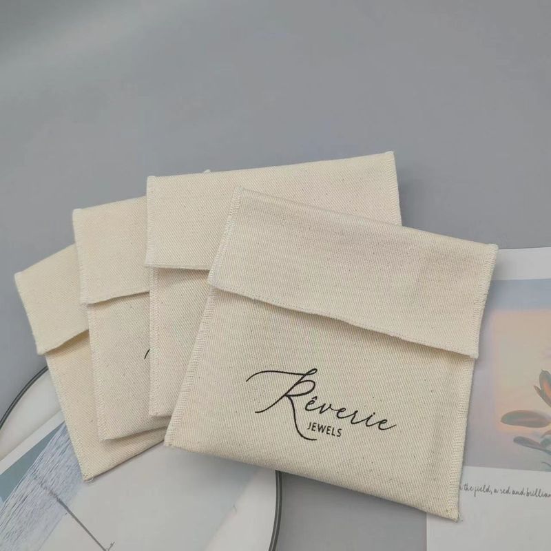 Pochette porte-cartes à rabat en toile sergée beige personnalisée, idéale pour ranger colliers, bracelets, bagues et boucles d'oreilles en argent._voghion.com