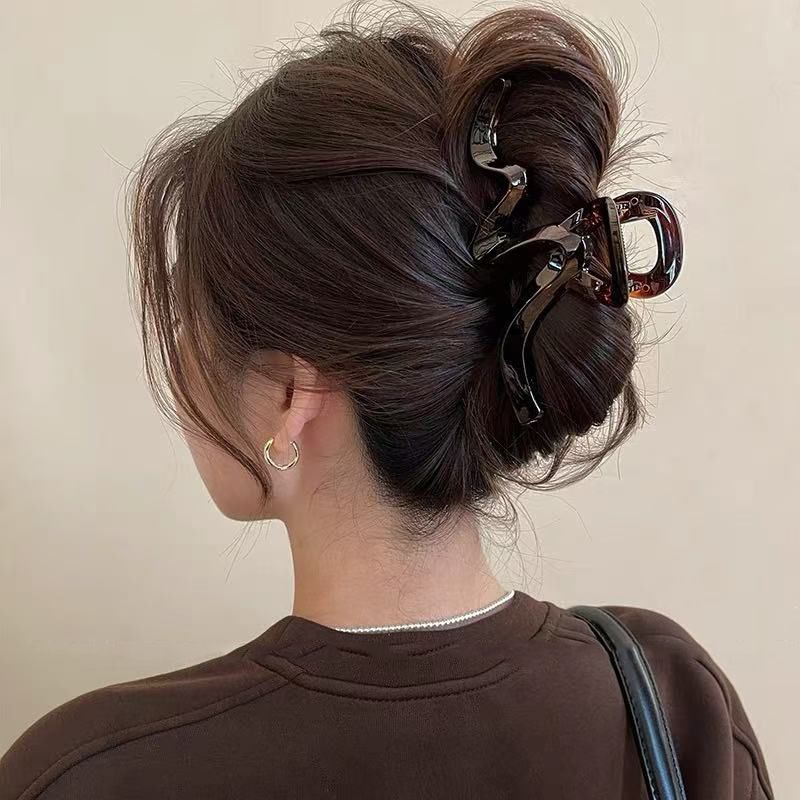 eine leicht lockige Frisur für anspruchsvolle Frauen mit Volumen und einer Haifischspange am Hinterkopf._voghion.com