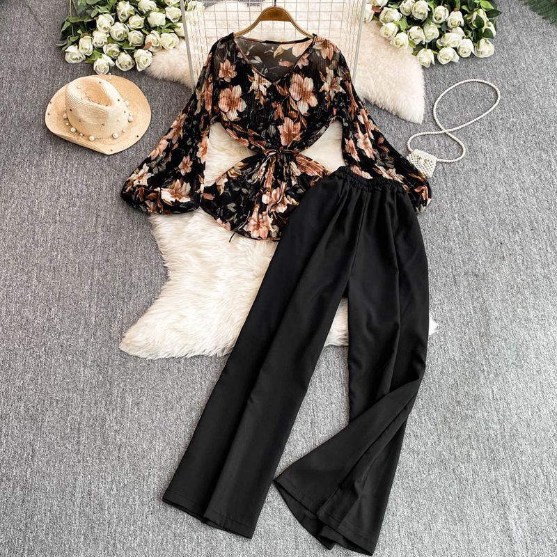 Completo da donna in due pezzi, stile maturo e leggero, con camicia a pieghe a fiori e vita ampia + pantaloni dritti a gamba larga e vita alta._voghion.com