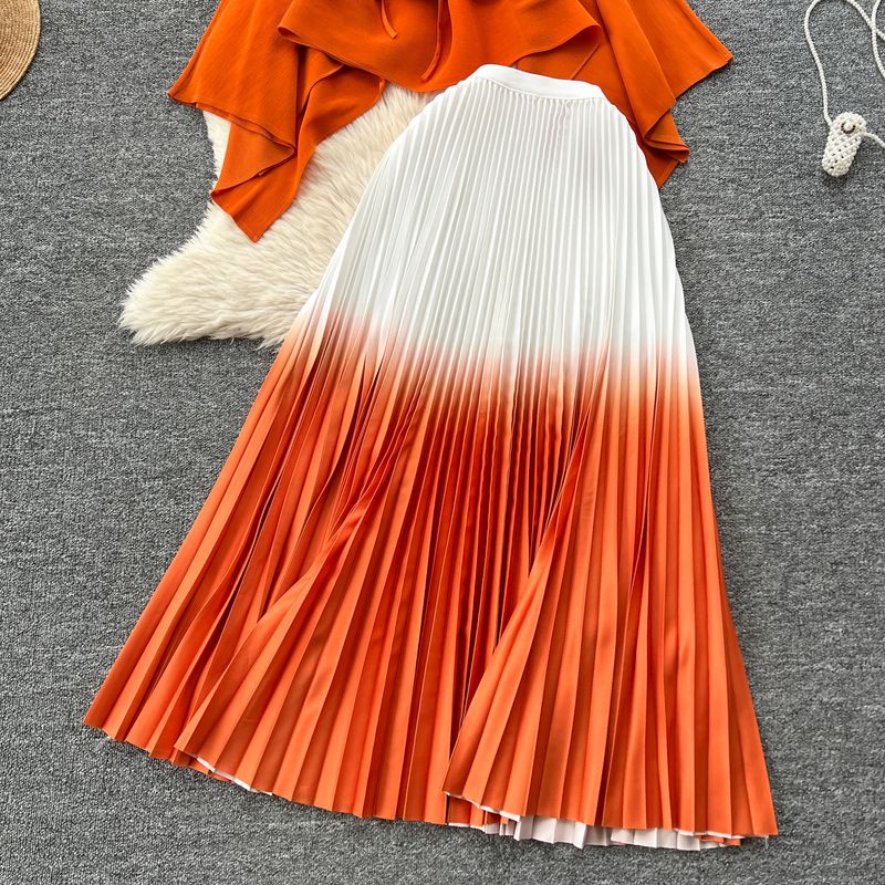 Abito da donna alla moda con colori sfumati, top plissettato con spalline larghe e gonna a pieghe a vita alta_voghion.com