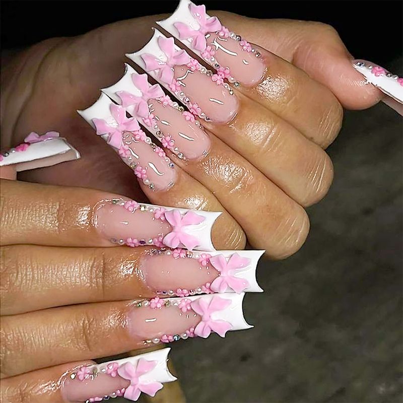 Eleganti unghie finte con fiocco rosa alla francese, strass e motivi floreali | Opzioni per colla e linguette adesive per unghie finte lunghe_voghion.com