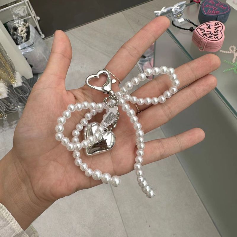 Parti e accessori per borse Nuovo ciondolo con fiocco di perle per ragazza dolce in argento Portachiavi con ciondolo con auricolare Bluetooth_voghion.com