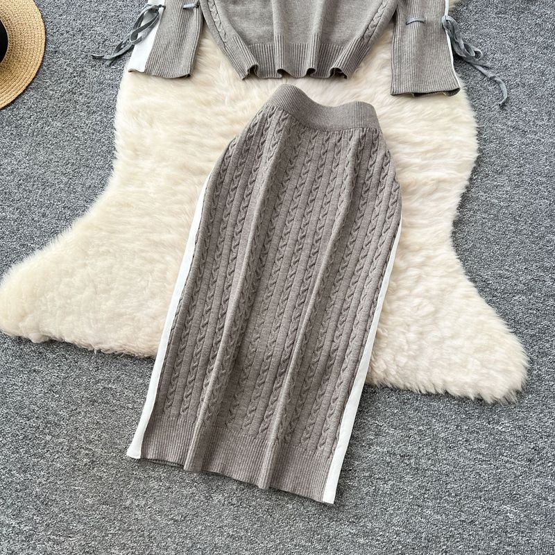 Elegante completo da donna in maglia a due pezzi: pullover a collo alto, maniche lunghe e gonna aderente, elegante color block per autunno e inverno._voghion.com