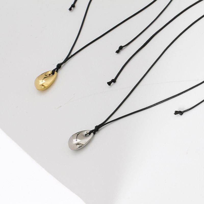 Collana con ciondolo a forma di fagiolo dorato, in acciaio al titanio e clavicola, lunga catena in corda di pelle nera, per coppia autunnale e invernale_voghion.com