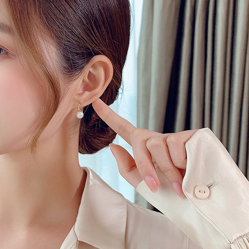 Ms. Wang's pearl earrings and high heels are simple in style, high-end and niche in design. Pearl earrings and ear hooks._voghion.com